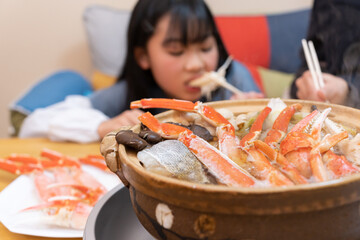 自宅でかに鍋を食べる日本人の家族