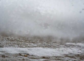 Blowing snow and Focus stacked ground level view of ice accumulation on a sidewalk with blowing...