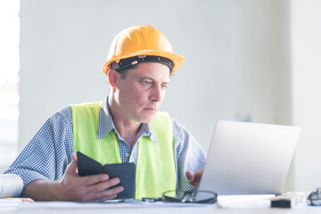 Architect concept, Architects working with blueprints in the office Business accessories (laptop, smartphone, pens, magnifier), accessories for drawing (plans, rulers) and learning on the table