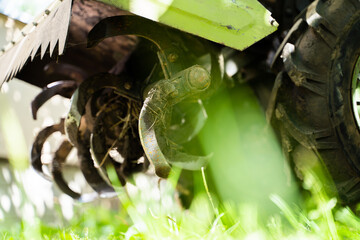 Rototiller of a walk-behind tractor close-up. Agricultural machinery for processing and care of the...