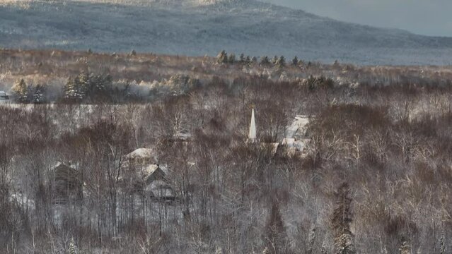 Monson Town seen through the snowy winter woodland