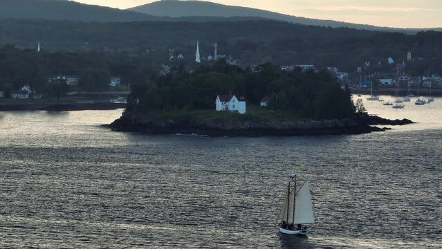 Classic wooden sailboat sailing toward Curtis Island Lighthouse Aerial