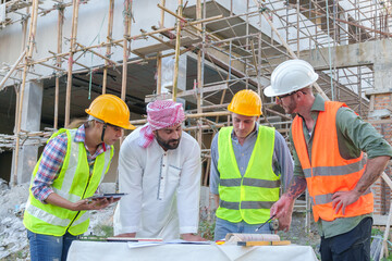 Diverse team of professionals using tablet computers on construction site. Real estate construction project. with civil engineers, architects, Arabic business investors and explorer with theodolite