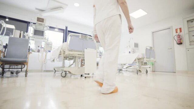 Female Nurse Doctor Wearing White Pants Walking Fast In Urgent Care Medical Center Hospital Private Clinic 