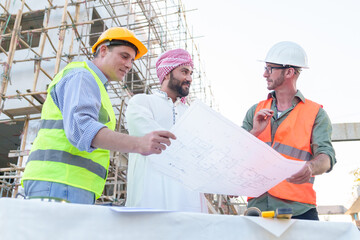 Diverse team of professionals using tablet computers on construction site. Real estate construction project. with civil engineers, architects, Arabic business investors and explorer with theodolite