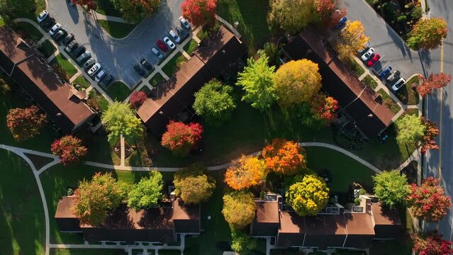 Top down aerial of American apartment building condo complex. Colorful fall foliage at golden hour light.