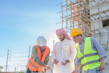 Diverse team of professionals using tablet computers on construction site. Real estate construction project. with civil engineers, architects, Arabic business investors and explorer with theodolite