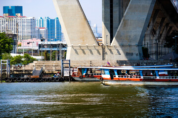 Boats on the water under the bridge in Bangkok, Thailand