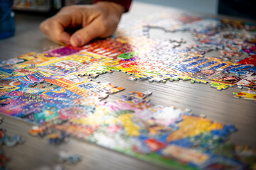 Close up of a hands holding puzzle pieces with others diffused