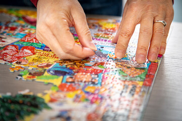 Close up of a hands holding puzzle pieces with others diffused