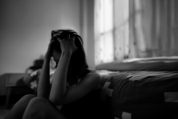A heartbroken teenage girl sits in the bedroom and regrets it. Depressive symptoms.
