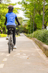 Rear view of Asian woman wearing helmet bike ride