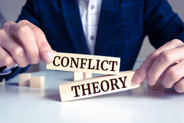 Wooden blocks with words 'CONFLICT THEORY'.