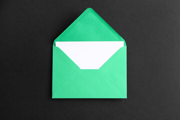 Green paper envelope with card on dark background