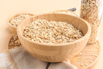 Wooden bowl with raw oatmeal on background, closeup