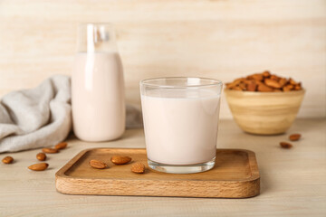 Glass of healthy almond milk on wooden table