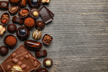 Chocolate bars and candies on wooden background