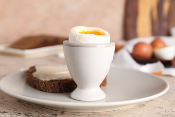 Plate with soft boiled egg and toast on table