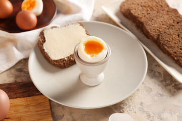 Plate with soft boiled egg and toast on table