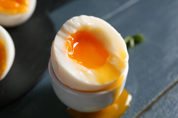 Holder with soft boiled egg on wooden table