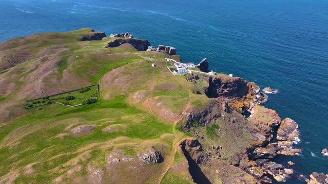 St. Abbs Lighthouse and coastal cliffs aerial view in summer near village of St. Abbs, Berwickshire, Scotland, UK. 