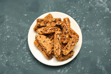 Plate with tasty biscotti cookies on grey table