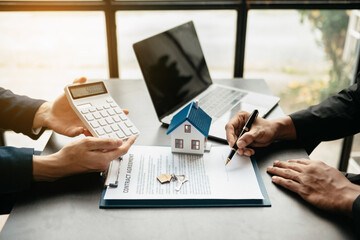 Real estate broker agent presenting and consult to customer to decision making sign insurance form agreement, home model, concerning mortgage loan offer