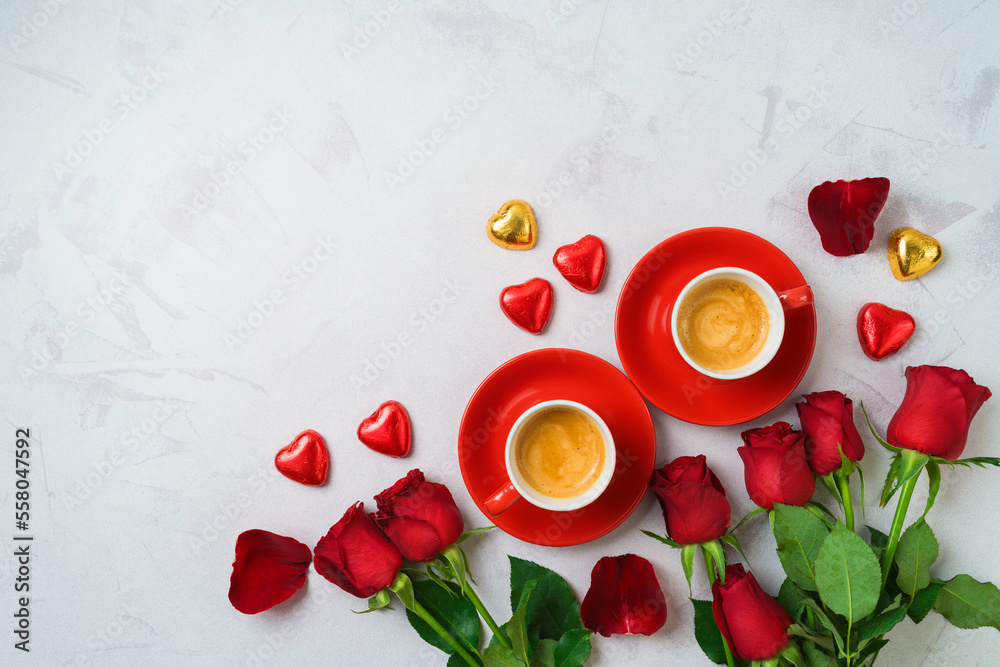 Wall mural Valentine's day romantic date concept. Coffee cups, heart shape chocolate and  rose flowers on modern background. Top view. Flat lay