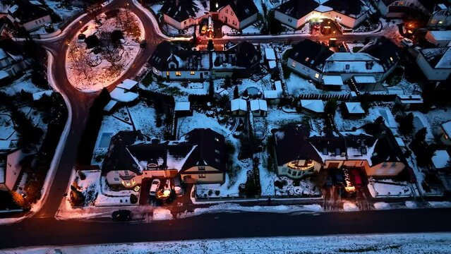 Aerial view of a snowy street with houses. Night lights and Christmas decorations on a cold winter night in the city of Svitavy, Czech Republic