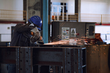Electric wheel grinding on steel structure in factory