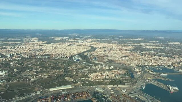 Aerial view of Valencia city, Spain, Mediterranean coast, from a jet cockpit, view fof the harbor, city and runway airport at the back, in a splendid day. Shot at 1000m high. Pilot point of view. 4k