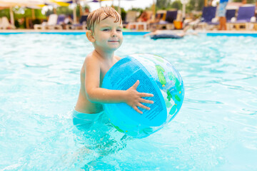 Kid swim, dive, leisure and playing inflatable ball in pool at vacation