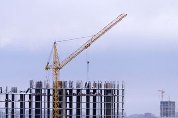 Fototapeta na wymiar Large tower crane up close. Copy space. Industrial engineering. Construction of mortgage housing.