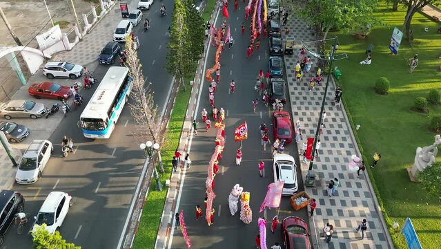 Top view of dragon dance perform celebration new year. Group of people perform a traditional lion dance and dragon dance. Guinness record performance of 54 Dragons dance on the street Vung Tau.