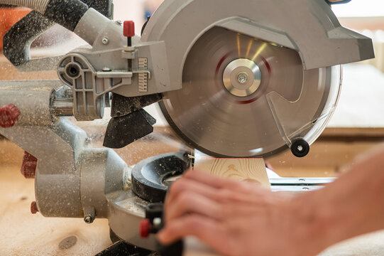 Master cuts the board with a circular saw in the workshop. 