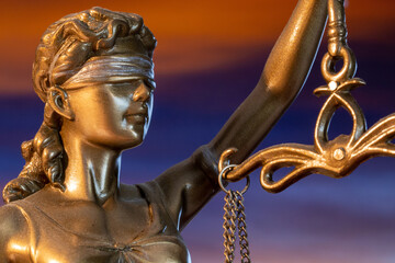 Nahaufnahme einer Justitia vor einem schönen Abendhimmel