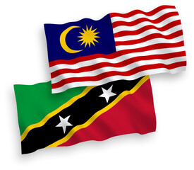 National vector fabric wave flags of Federation of Saint Christopher and Nevis and Malaysia isolated on white background. 1 to 2 proportion.