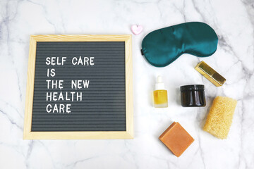 Letter board with phrase self care is the new health care background, sleeping mask, organic natural essential oil,skincare,cosmetics, heart. Concept mental health, self love, Aspiration, supportive.