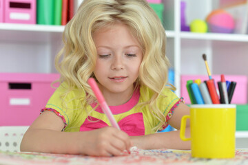 girl drawing picture at desk at home