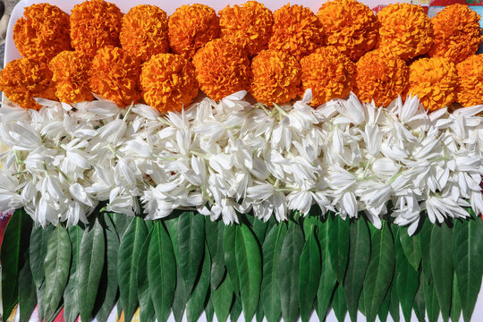 Indian Tricolor theme of Indian National Flag made of Orange marigold flowers, White jasmine flowers and Green fresh leaves.