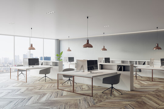 Perspective view on stylish sunlit open space office with light furniture, modern computers, dark chairs on wooden parquet floor and city view from panoramic window background. 3D rendering
