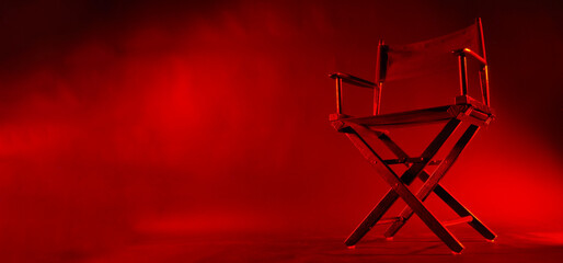 Director chair isolated in red light color with black background