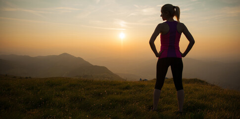 beautiful young woman runns cross country on a mountian path at sunrise