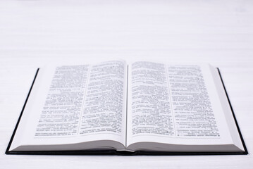 Obraz premium An open Bible on the table. Prayer to pray. On a white background