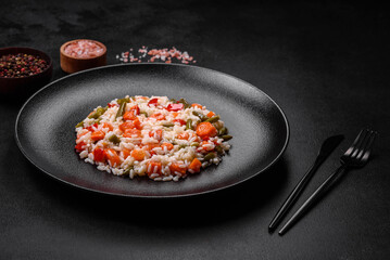 Delicious fresh risotto with vegetables, spices and herbs on a black plate