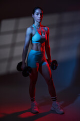 Fototapeta na wymiar Fitness woman model with great body working out in red blue toning light