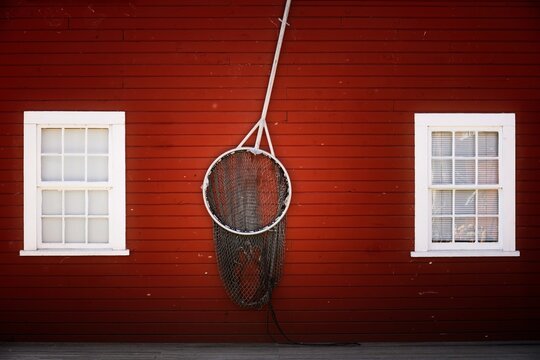 A decorative brailer on a red wooden wall of a house