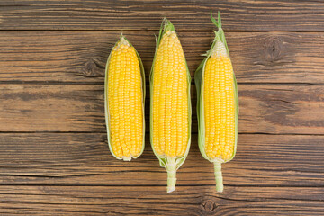 Fresh corn on the cob on a rustic wooden table - top view