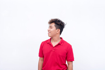 Obraz premium A hopeful young man looking at the left. Visualizing happiness. Isolated on a white background.