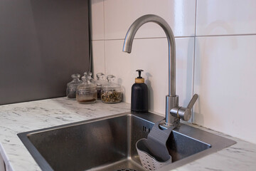 Kitchen sink with apron and chrome faucet